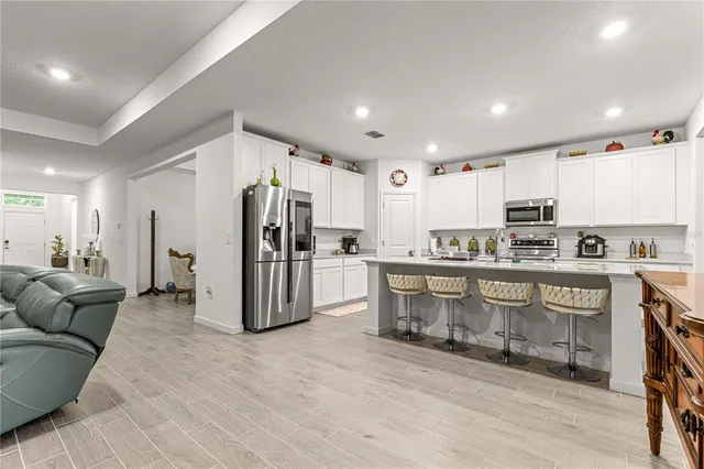 a kitchen with white cabinets sink and stainless steel appliances