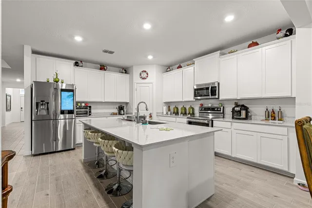 a kitchen with a sink a counter top space appliances and cabinets