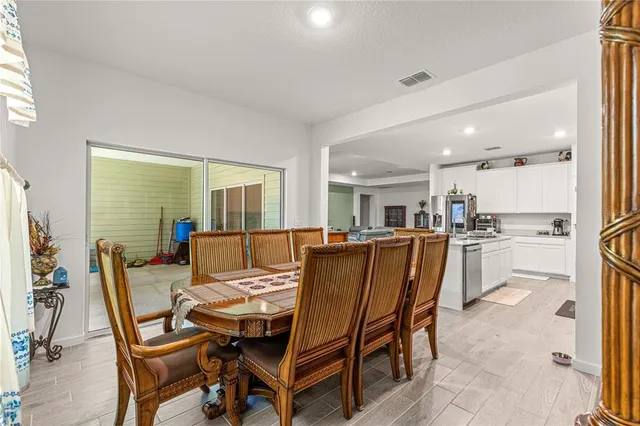 a living room with couches and kitchen view with wooden floor