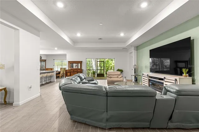 a living room with furniture fireplace and large windows