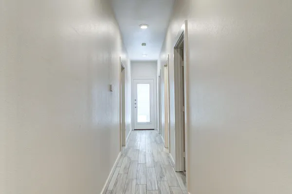 a view of a hallway with wooden floor