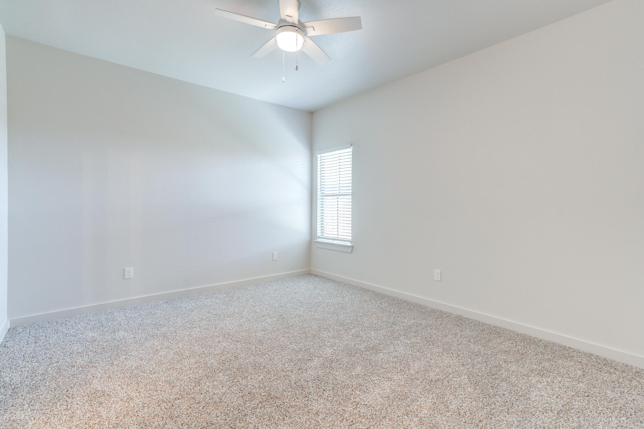 7040 41st Street Lubbock, TX 79407 - Photo 20 of 22 an empty room with a window and chandelier fan