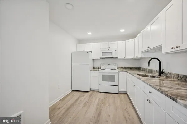 a kitchen with white cabinets stainless steel appliances and sink