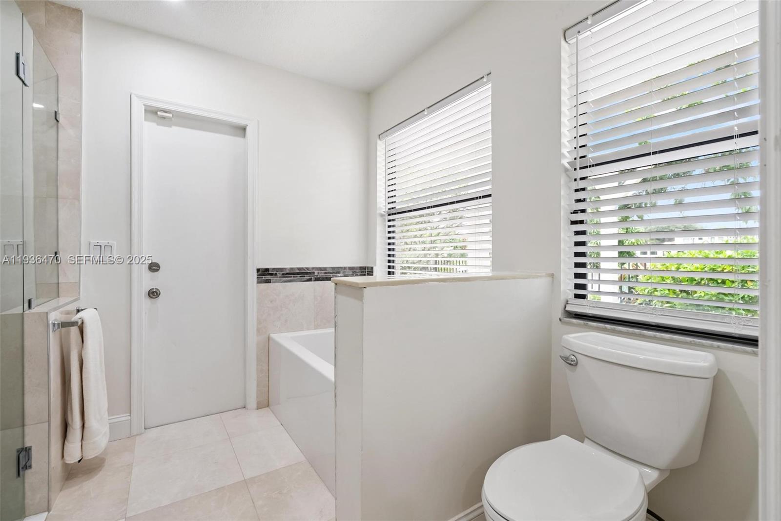 2685 Northwest 27th Terrace Boca Raton, FL 33434 - Photo 14 of 31 a white toilet sitting next to a window in a bathroom