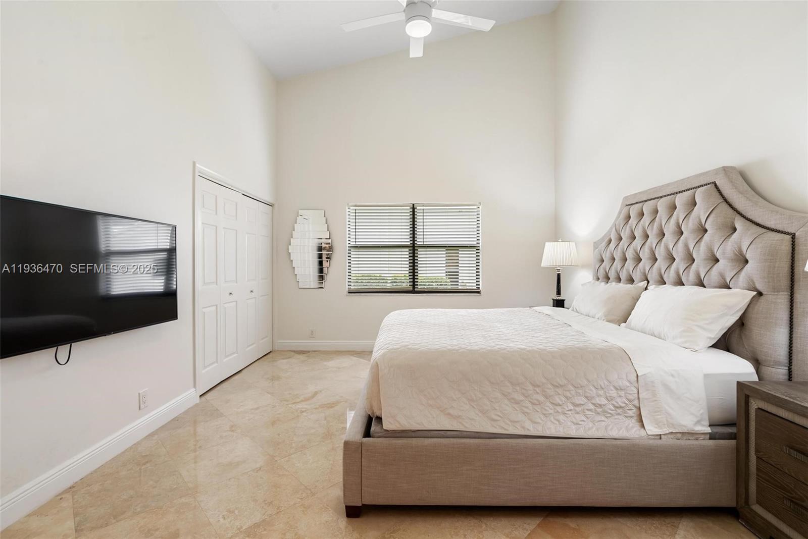 2685 Northwest 27th Terrace Boca Raton, FL 33434 - Photo 17 of 31 a bedroom with a large bed and a flat screen tv