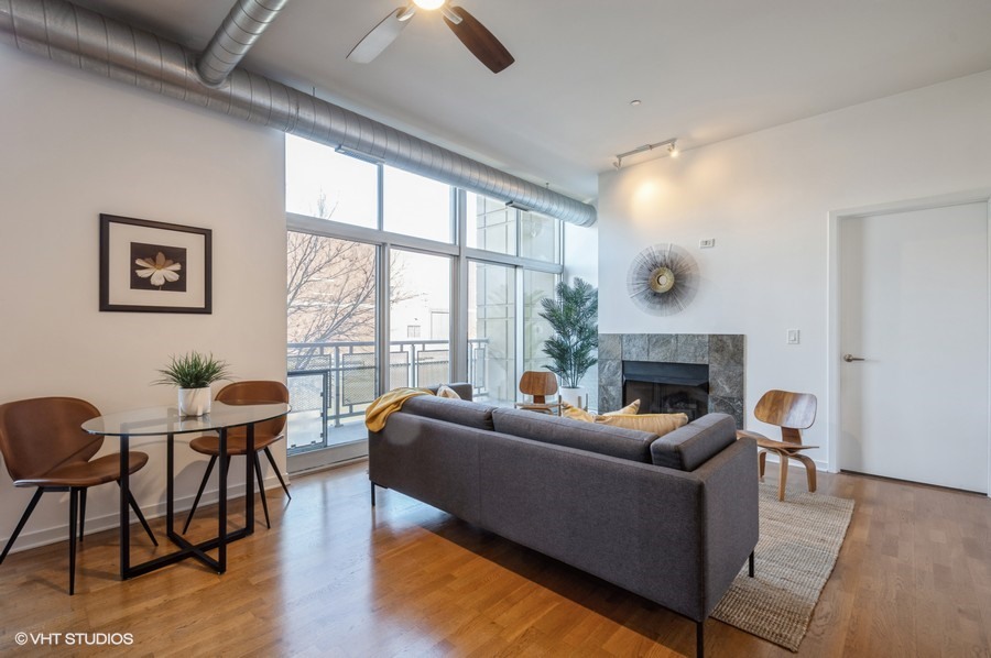 700 North Larrabee Street, Unit 115 Chicago, IL 60654 - Photo 2 of 11 a living room with furniture a fireplace and large windows