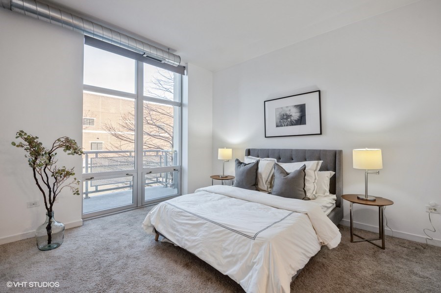 700 North Larrabee Street, Unit 115 Chicago, IL 60654 - Photo 6 of 11 a bedroom with a bed and a night stand