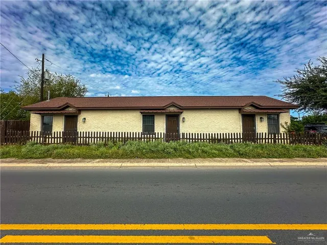 a view of a brick house next to a yard
