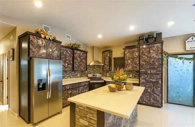 a kitchen with stainless steel appliances granite countertop a refrigerator and a stove