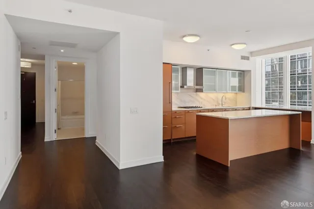 a open kitchen with granite countertop a stove and wooden floor