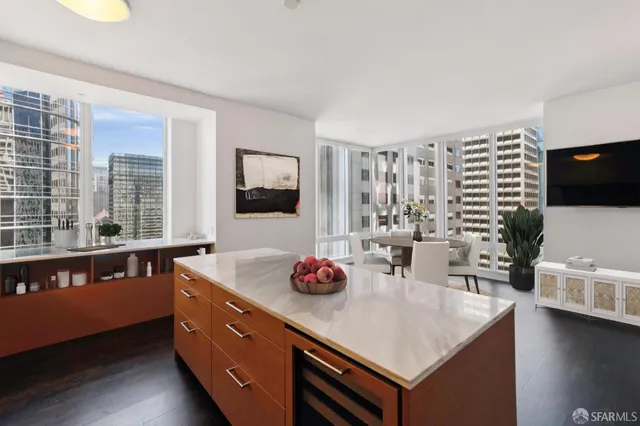 a kitchen with stainless steel appliances granite countertop a sink dishwasher and a flat screen tv