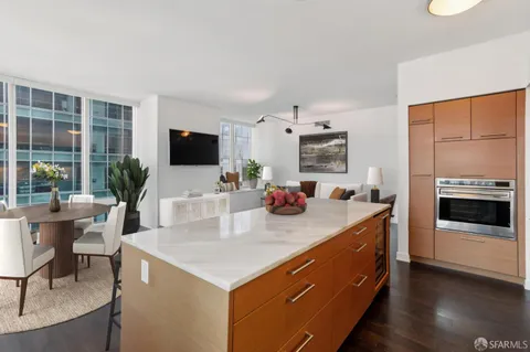 a view of kitchen island a sink wooden floor and a living room