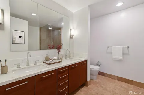 a bathroom with a granite countertop sink mirror and toilet