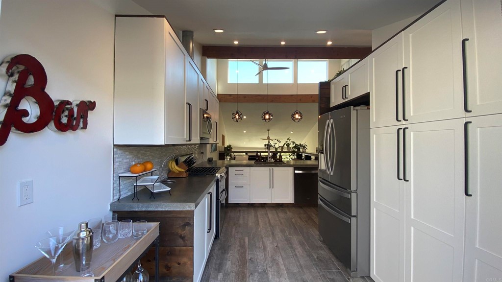 a kitchen with a refrigerator and wooden floor