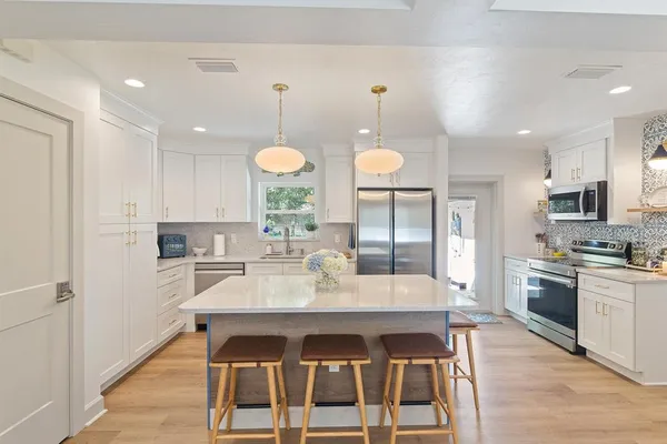 a kitchen with granite countertop a sink cabinets and stainless steel appliances