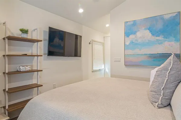 a bedroom with a bed and a painting on the wall
