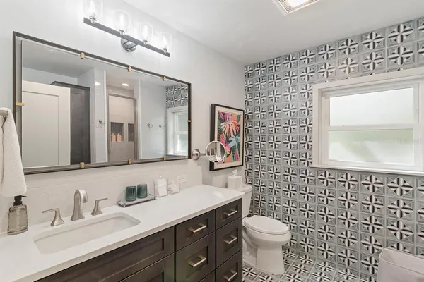 a bathroom with a toilet sink vanity and mirror