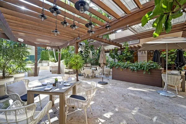 a view of a patio with a table and chairs under an umbrella