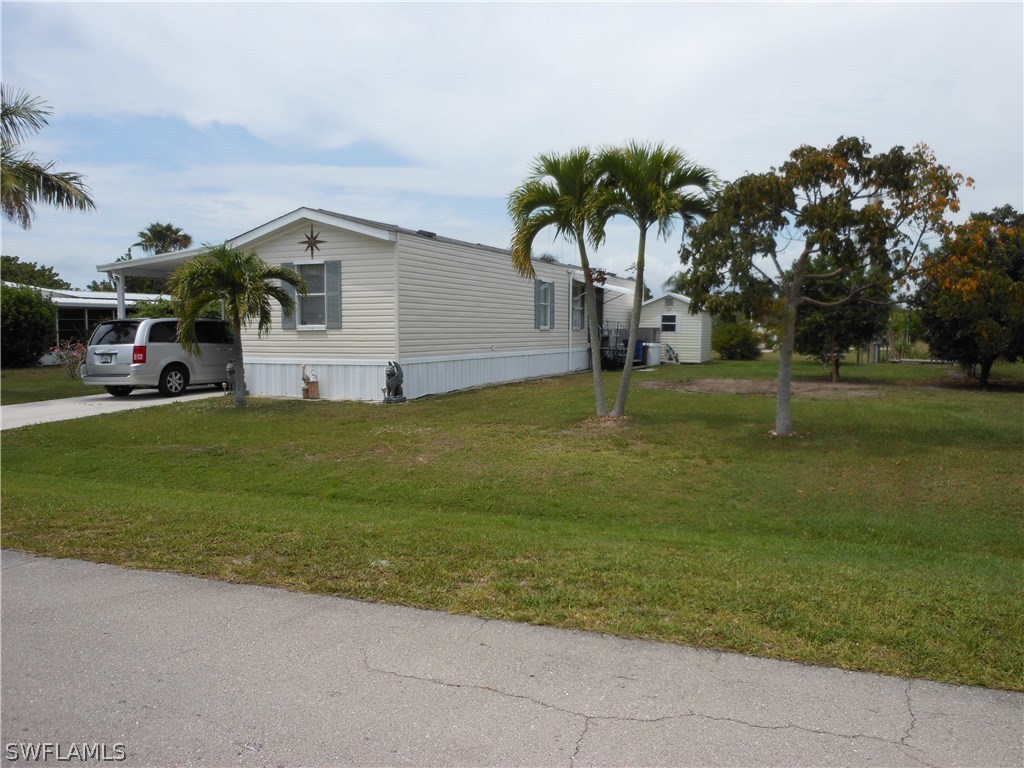 7664 Helen Road Bokeelia, FL 33922 - Photo 15 of 17 a big white house with a big yard and palm trees