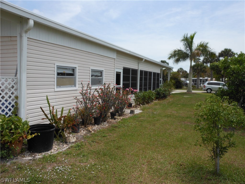 7664 Helen Road Bokeelia, FL 33922 - Photo 17 of 17 a view of backyard of house with outdoor seating and green space