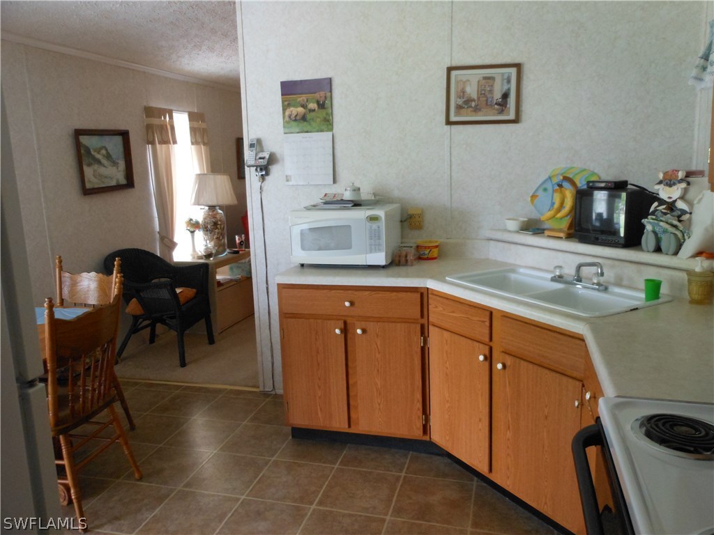 7664 Helen Road Bokeelia, FL 33922 - Photo 5 of 17 a kitchen with sink cabinets and appliances
