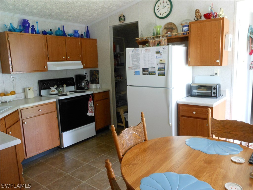 7664 Helen Road Bokeelia, FL 33922 - Photo 6 of 17 a kitchen with stainless steel appliances granite countertop a refrigerator a stove top oven a sink and dishwasher
