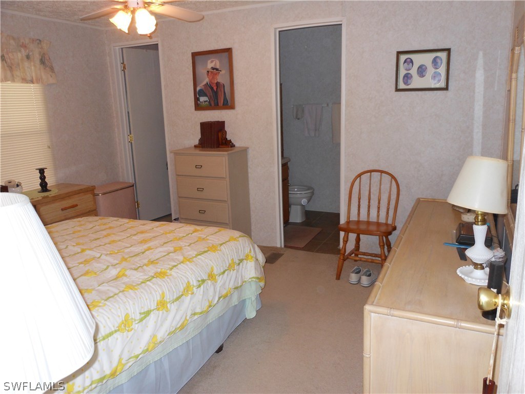 7664 Helen Road Bokeelia, FL 33922 - Photo 9 of 17 a bedroom with a bed and a chandelier
