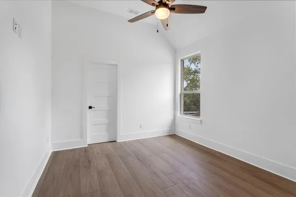 an empty room with a window and a ceiling fan