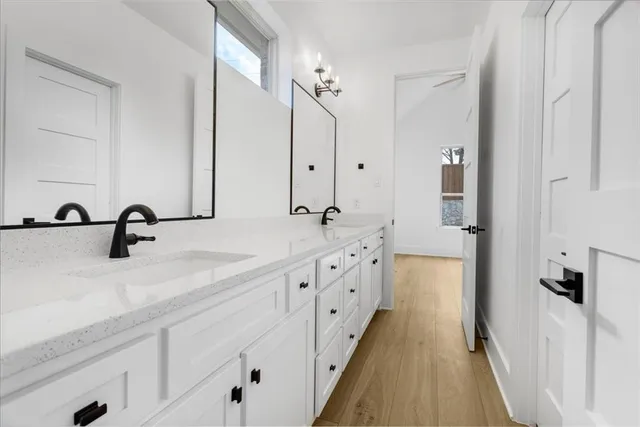 a spacious bathroom with double sink and mirror