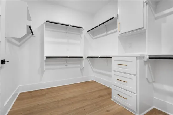a view of walk in closet with empty racks