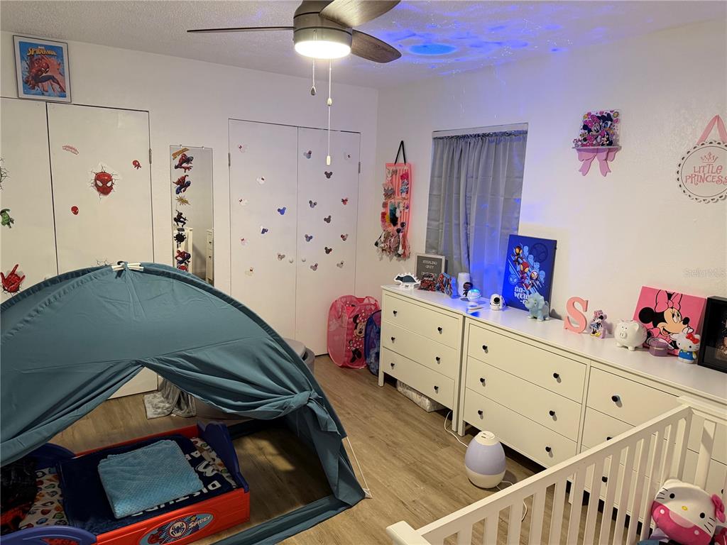 1150 Bentley Avenue Spring Hill, FL 34608 - Photo 7 of 11 a bedroom with a bed and wooden floor