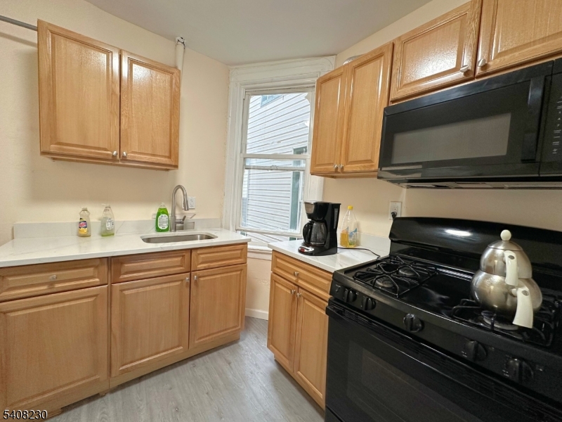 276 Atlantic Street, Unit 2 Paterson, NJ 07503 - Photo 4 of 6 a kitchen with stainless steel appliances a stove microwave and sink