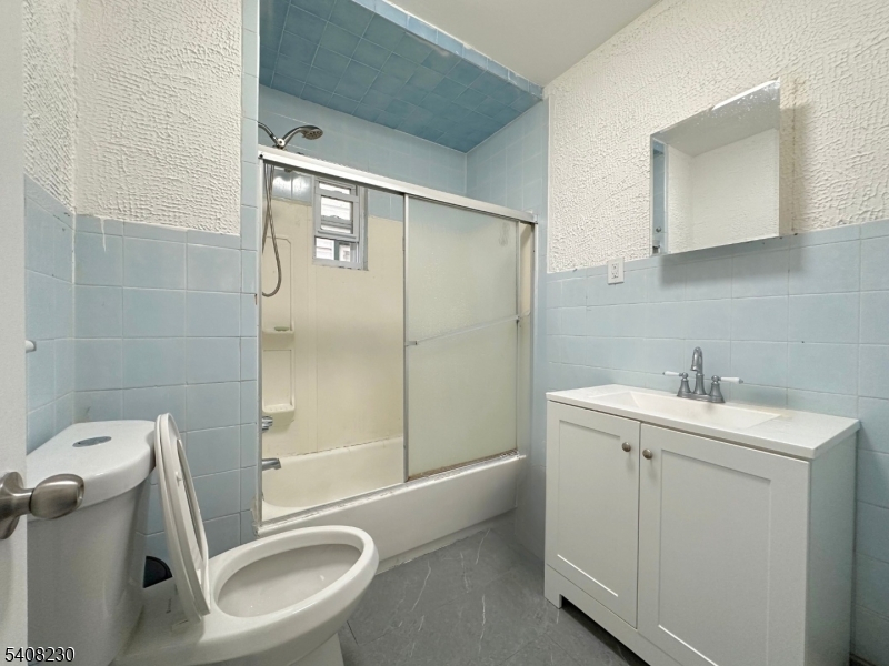 276 Atlantic Street, Unit 2 Paterson, NJ 07503 - Photo 5 of 6 a bathroom with a sink a toilet and shower
