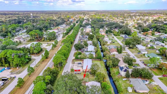 an aerial view of residential houses with outdoor space and trees