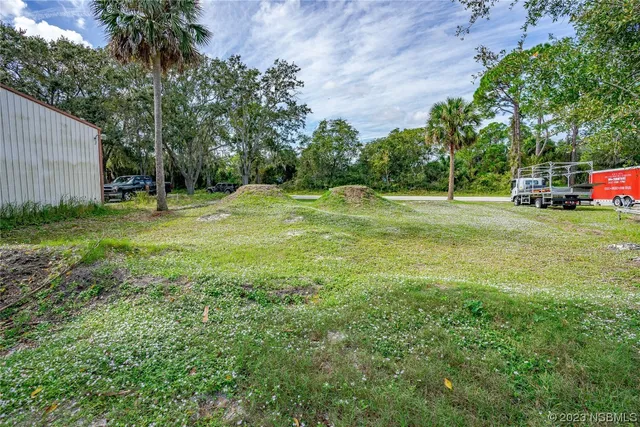 a backyard of a house with table and chairs