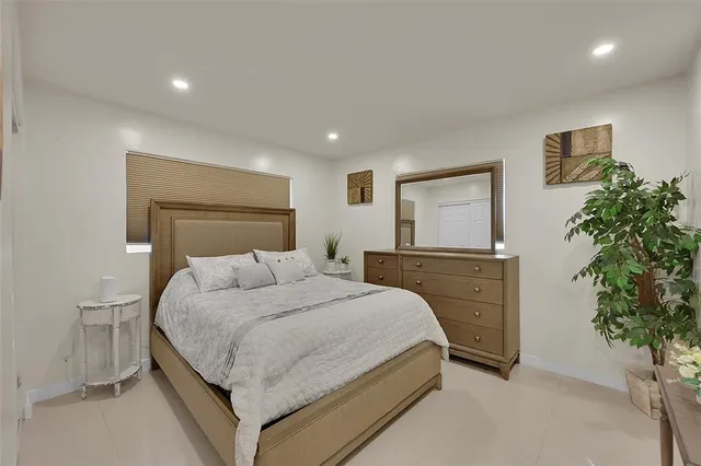 a bedroom with a large bed and a potted plant