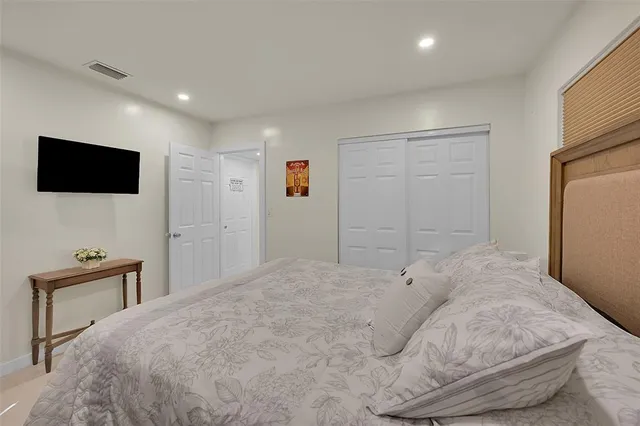 a bedroom with a bed and a flat screen tv