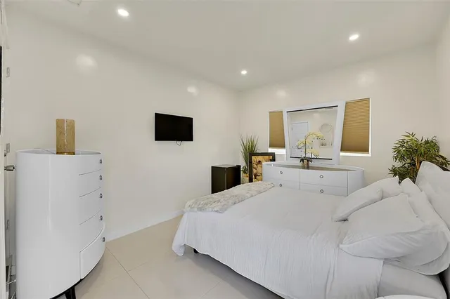 a living room with a bed furniture and a flat screen tv