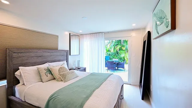 a bedroom with a bed lamp and a large window