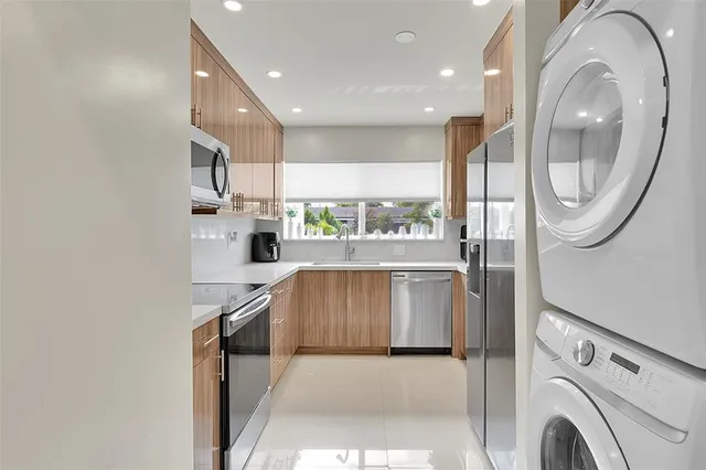 a kitchen with kitchen island a stove a refrigerator and a sink