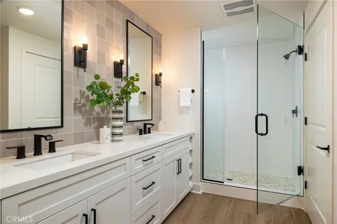 a bathroom with a double vanity sink mirror and shower