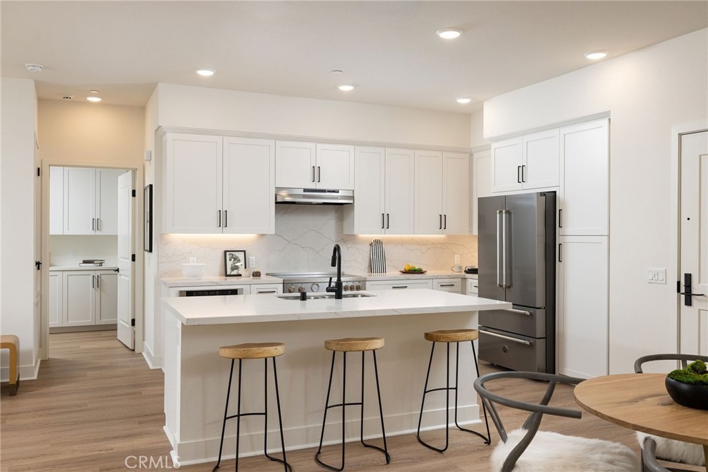 414 Main Street, Unit 410 Huntington Beach, CA 92648 - Photo 8 of 25 a kitchen with stainless steel appliances granite countertop a sink a stove a refrigerator and cabinets