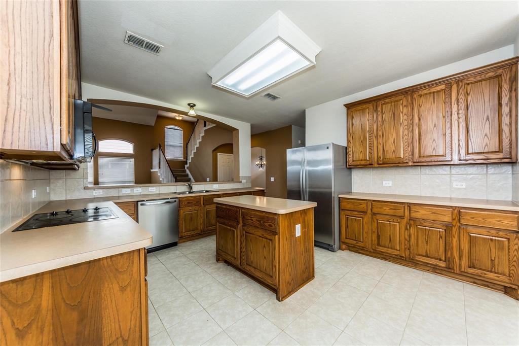 413 Sunrise Drive Allen, TX 75002 - Photo 7 of 23 a kitchen with stainless steel appliances granite countertop a sink stove and refrigerator