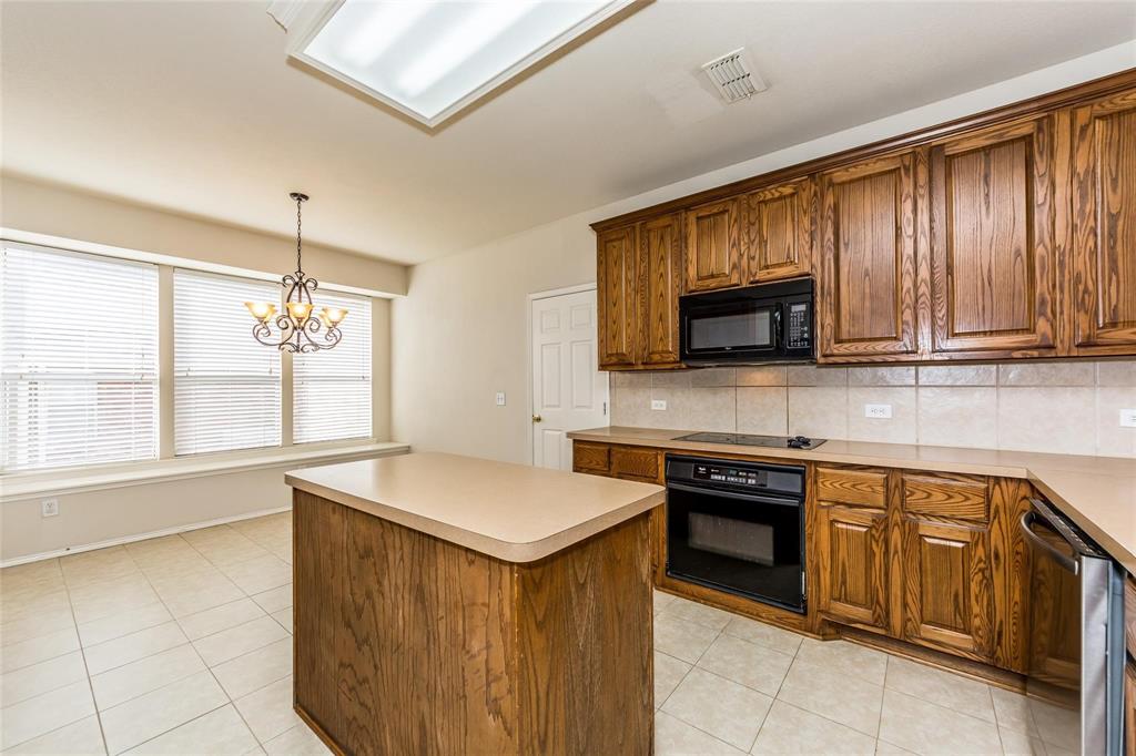 413 Sunrise Drive Allen, TX 75002 - Photo 9 of 23 a kitchen with stainless steel appliances granite countertop a sink dishwasher stove and microwave with wooden cabinets