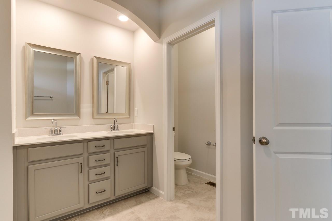 6055 Beale Loop, Unit 25 ABBEY Raleigh, NC 27616 - Photo 16 of 27 a bathroom with a double vanity sink a mirror and a toilet