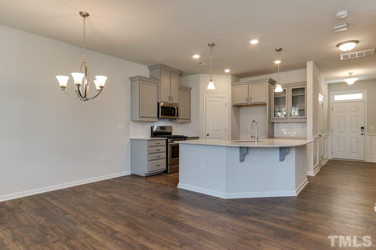6055 Beale Loop, Unit 25 ABBEY Raleigh, NC 27616 - Photo 5 of 27 a large kitchen with stainless steel appliances granite countertop a large stove a sink dishwasher and a refrigerator with wooden floor