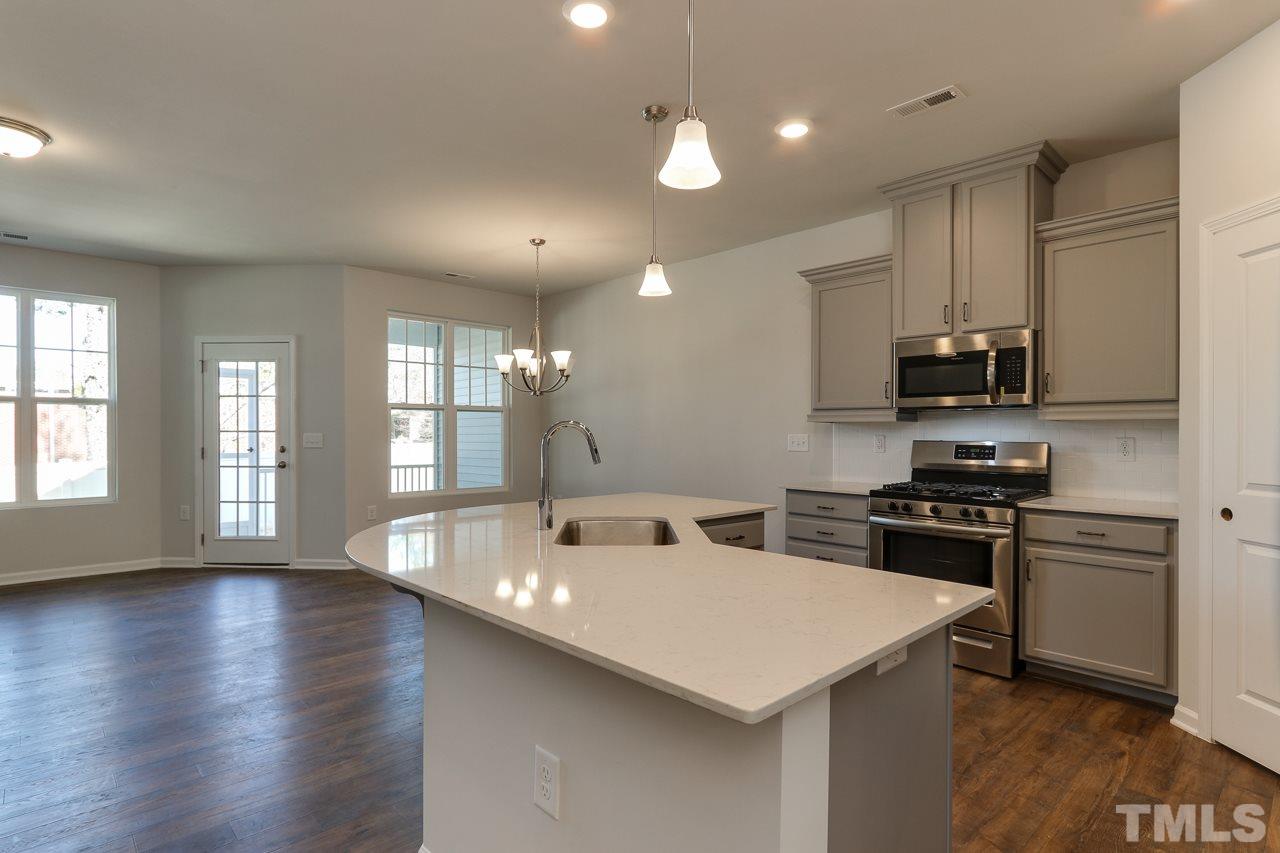 6055 Beale Loop, Unit 25 ABBEY Raleigh, NC 27616 - Photo 6 of 27 a kitchen with stove a microwave and wooden floor