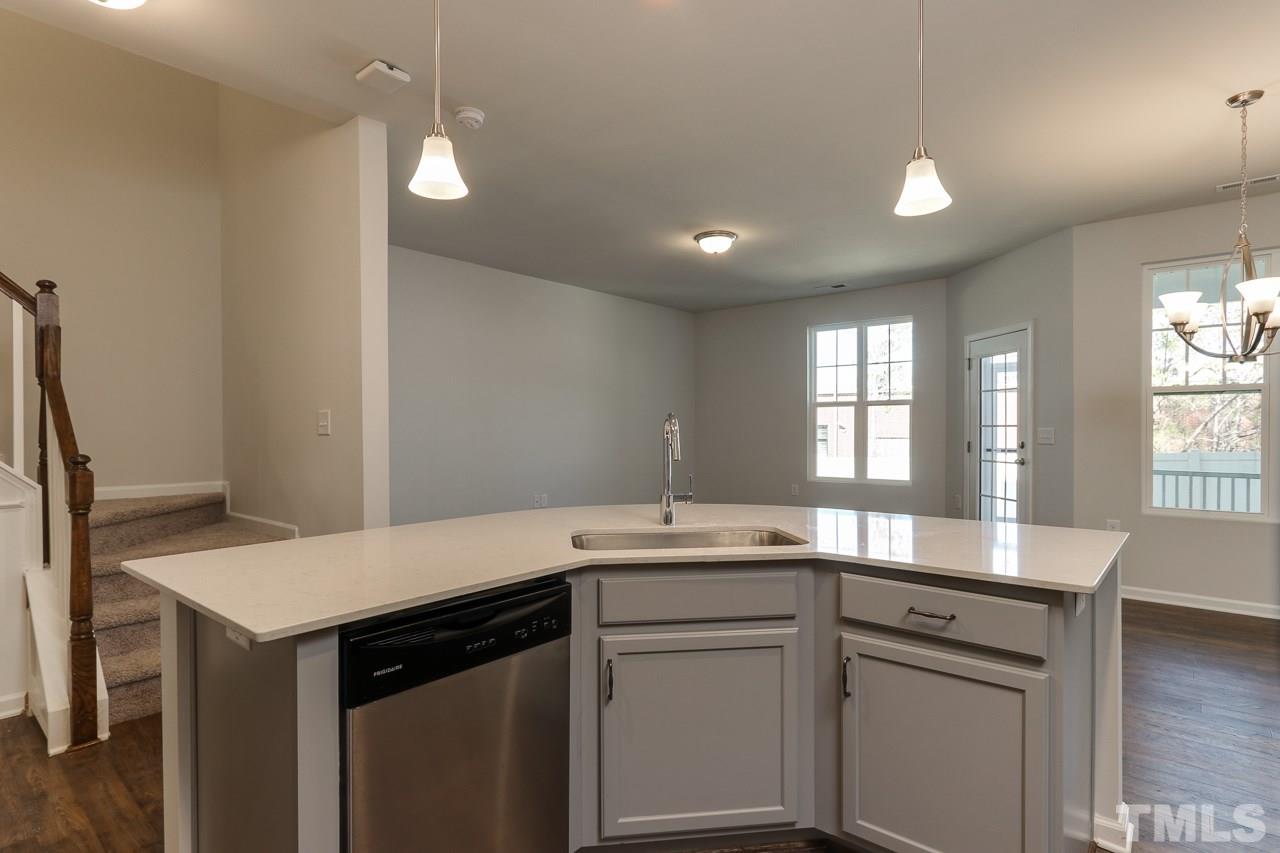 6055 Beale Loop, Unit 25 ABBEY Raleigh, NC 27616 - Photo 7 of 27 a kitchen that has a sink a window in it and wooden floors
