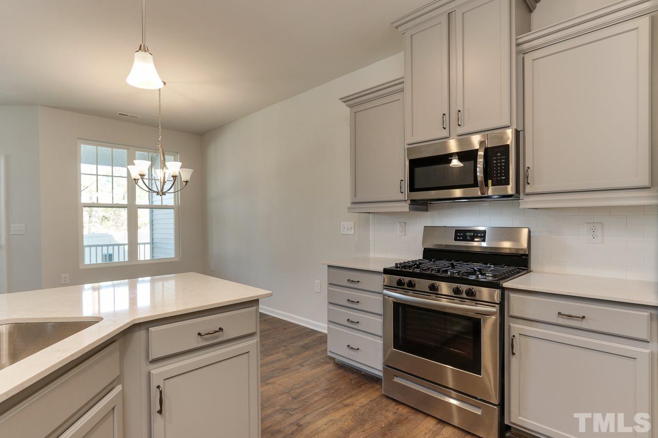 6055 Beale Loop, Unit 25 ABBEY Raleigh, NC 27616 - Photo 8 of 27 a kitchen with stainless steel appliances a stove microwave and sink