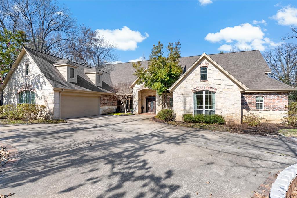 a front view of a house with a dirt yard and a garage